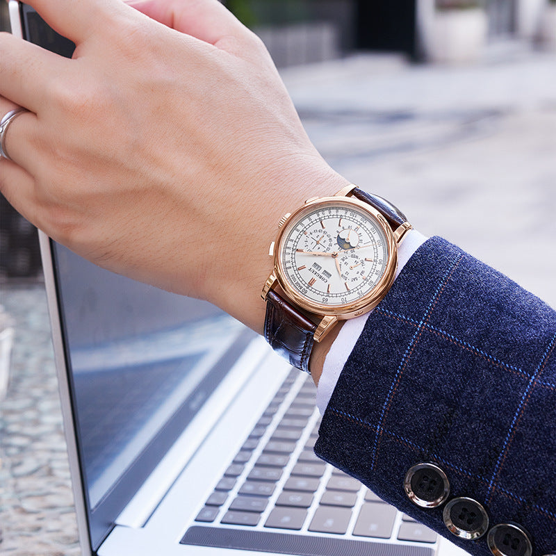 Hand wearing a watch on a blurred outdoor background